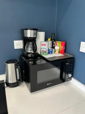 a black coffee maker sitting on top of a counter at Èze - Appartement dans bas de villa avec piscine près de Monaco in Èze