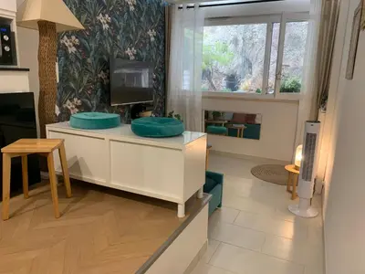 a living room with a tv on a dresser with blue pillows at L'îlot Bornala in Nice