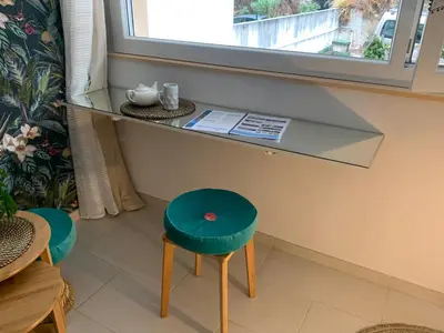 a glass counter with a stool and a window at L'îlot Bornala in Nice