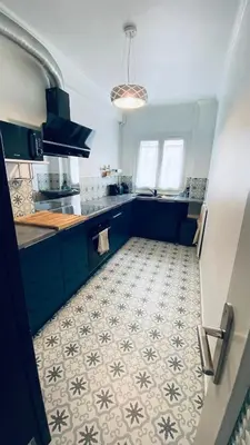a kitchen with blue cabinets and a tile floor at Confortable et Spacieux 3pièces, très bien situé in Nice