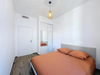 a bedroom with a bed with orange pillows on it at Le Francis - Riquier Port de Nice in Nice