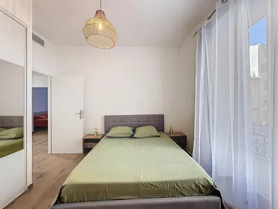 a bedroom with a bed and a large window at Le Francis - Riquier Port de Nice in Nice