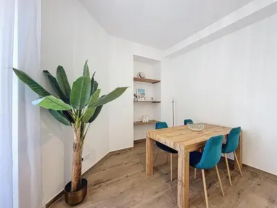 a dining room with a table and a potted plant at Le Francis - Riquier Port de Nice in Nice