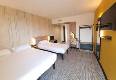 a hotel room with two beds and a desk at B&B HOTEL Nice Stade Riviera in Nice