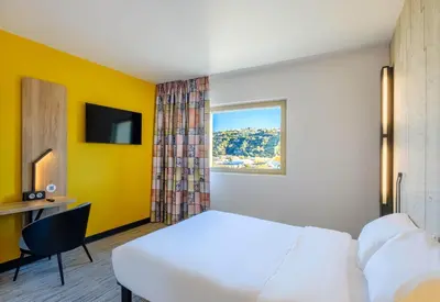 a hotel room with a white bed and a window at B&B HOTEL Nice Stade Riviera in Nice