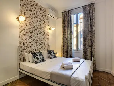 a bedroom with a bed and a window at Nestor&Jeeves - PALAZZO VERDI - Central in Nice
