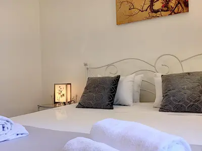 a bedroom with a bed with white sheets and pillows at Nestor&Jeeves - PALAZZO VERDI - Central in Nice