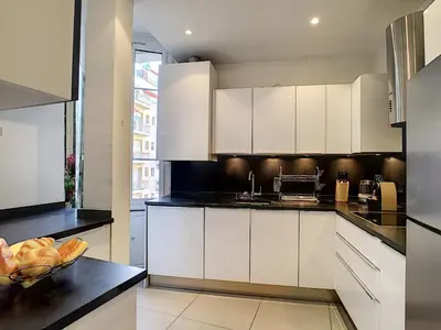 a kitchen with white cabinets and a bowl of fruit on a counter at Nestor&Jeeves - PALAZZO VERDI - Central in Nice