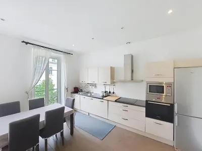 a kitchen with a dining table and a white refrigerator at Nestor&Jeeves - DOLCE VITA MASTER - Jean Medecin in Nice