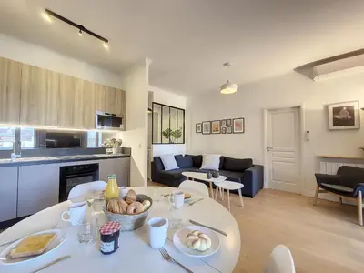 a kitchen and living room with a table in a room at Nestor&Jeeves - MADAGASCAR - 3 chambres, Centre-ville in Nice