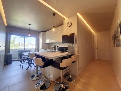 a kitchen and dining room with a table and chairs at Nestor&Jeeves - FLEURS TERRASSE - 3 chambres in Nice