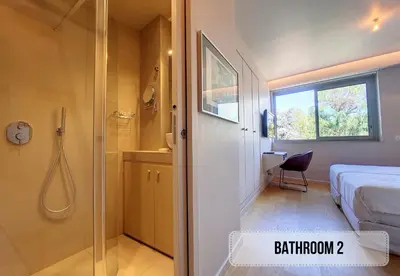 a bathroom with a shower and a bed and a window at Nestor&Jeeves - FLEURS TERRASSE - 3 chambres in Nice