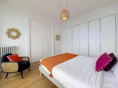 a bedroom with a large bed and a chair at Nestor&Jeeves - MEDITERRANEE PROMENADE - Vue Mer in Nice