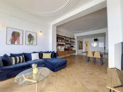 a living room with a blue couch and a glass table at Nestor&Jeeves - MEDITERRANEE PROMENADE - Vue Mer in Nice