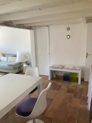 a living room with a couch and a table and chairs at Charmant deux pièces dans le quartier du Port in Nice
