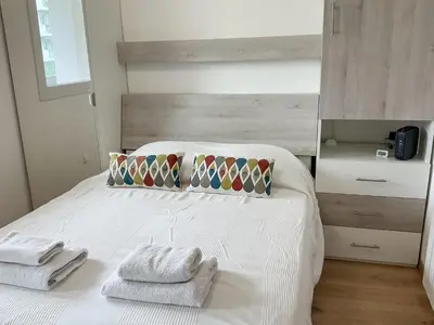 a bedroom with a white bed with towels on it at La Prom 2 - a two bedroom apartment with a sea view in Nice