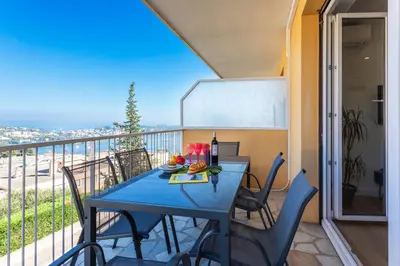 a blue table and chairs on a balcony at LE MONT ALBAN AP4360 By Riviera Holiday Homes in Villefranche-sur-Mer