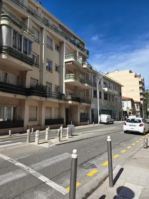 a street with cars parked in front of a building at Gloria apartments in Nice
