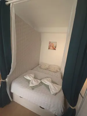 a small bed with white sheets and pillows at Gloria apartments in Nice