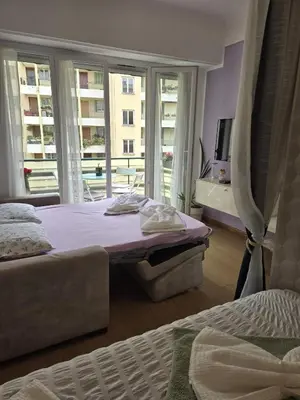 a bedroom with two beds and a large window at Gloria apartments in Nice