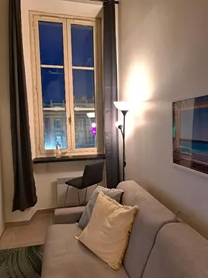 a living room with a couch and a window at Massena square View 2 min to the beach & the old town in Nice