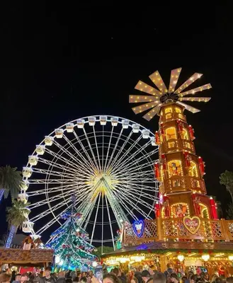 a carnival with a ferris wheel at night at Massena square View 2 min to the beach & the old town in Nice