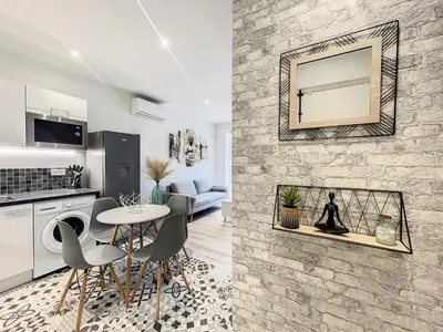 a kitchen and a living room with a table and chairs at Escapades Ensoleillées in Nice