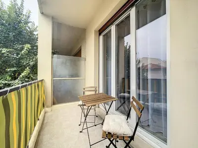 a patio with a table and chairs on a balcony at Escapades Ensoleillées in Nice