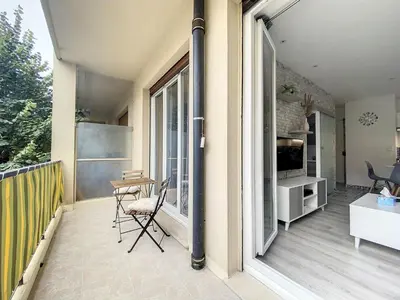 a balcony with a table and chairs and a window at Escapades Ensoleillées in Nice