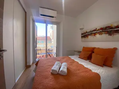 a bedroom with a bed with two slippers on it at PACA01 in Nice