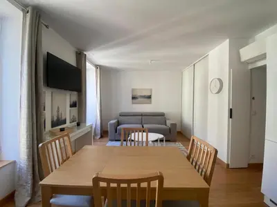 a dining room with a table and chairs and a couch at PACA01 in Nice