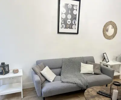 a living room with a gray couch and a table at Sublime Appartement 2 pièces au cœur de la Vieille Ville in Nice