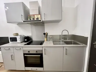a white kitchen with a sink and a microwave at Sublime Appartement 2 pièces au cœur de la Vieille Ville in Nice