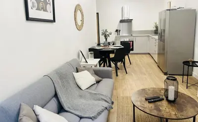 a living room with a blue couch and a kitchen at Sublime Appartement 2 pièces au cœur de la Vieille Ville in Nice