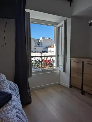 a bedroom with a large window with a balcony at Holiday Nice Studio in Nice