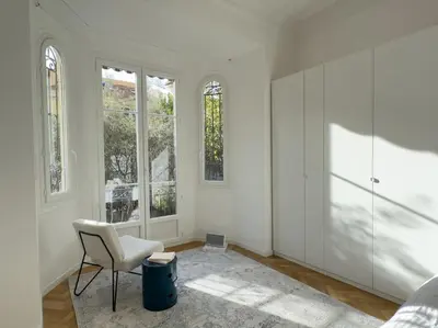 a white room with a chair and windows at Luxury flat for 6 in center of Nice By ask me france in Nice