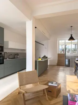 a living room with a chair and a kitchen at Luxury flat for 6 in center of Nice By ask me france in Nice