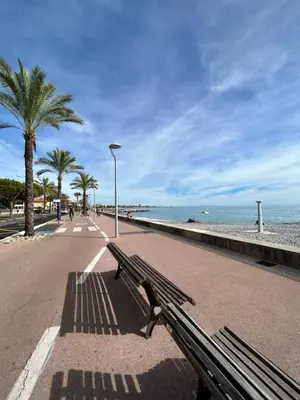 a bench on a sidewalk next to the beach at Riviera 1 ou Riviera 2 ou réservez les 2 Front de Mer Cagnes sur Mer Promenade de la plage in Cagnes-sur-Mer