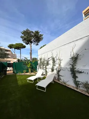 two white chairs sitting on the grass next to a building at Riviera 1 ou Riviera 2 ou réservez les 2 Front de Mer Cagnes sur Mer Promenade de la plage in Cagnes-sur-Mer