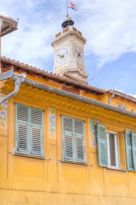 a yellow building with a clock tower on top of it at 26 nice Vieux Nice in Nice
