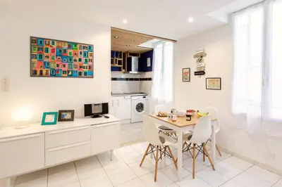 a kitchen with white cabinets and a table and chairs at 26 nice Vieux Nice in Nice