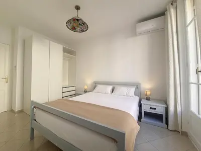 a white bedroom with a bed and a window at Nestor&Jeeves - JACARANDA - Carre d Or, Proche mer in Nice