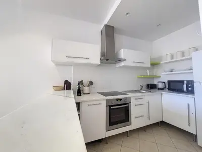 a white kitchen with white cabinets and a counter top at Nestor&Jeeves - JACARANDA - Carre d Or, Proche mer in Nice