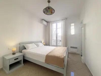 a white bedroom with a bed and a window at Nestor&Jeeves - JACARANDA - Carre d Or, Proche mer in Nice