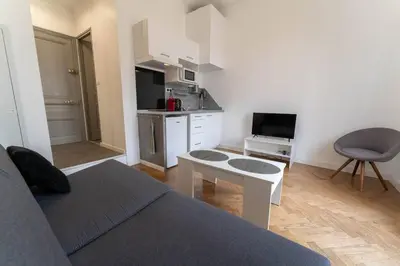 a living room with a couch and a kitchen at Nice Centre STUDIO avec BALCON in Nice