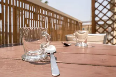 a glass mug and a spoon on a wooden table at Nice Centre STUDIO avec BALCON in Nice