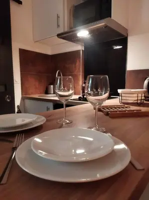 a table with two plates and two wine glasses on it at NICE Centre-ville Studio en étage refait à neuf in Nice
