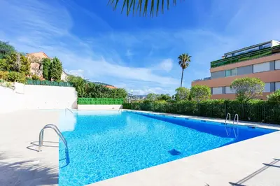 a swimming pool in front of a building at Agrianthe Palmiers AP4380 By Riviera Holiday Homes in Villefranche-sur-Mer