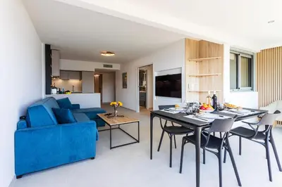 a living room with a blue couch and a table at Agrianthe Palmiers AP4380 By Riviera Holiday Homes in Villefranche-sur-Mer