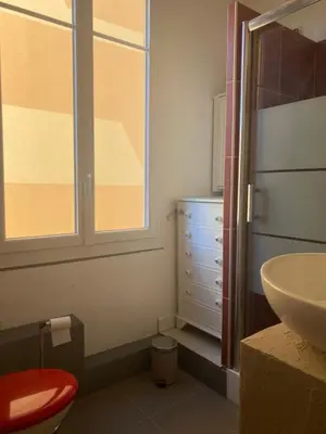 a bathroom with a sink and a toilet and a window at appartement cosy in Nice